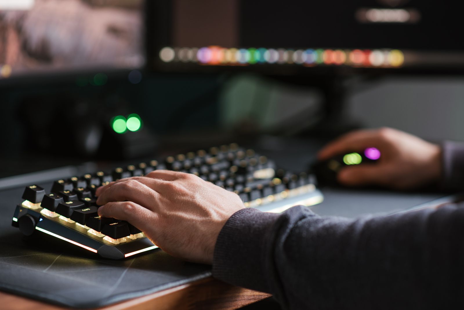 赤く光るキーボードを操作する手元のクローズアップ